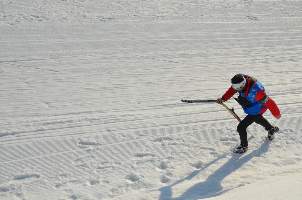 Тренер сборной Канады Джастин Уодсворт несет сломанную лыжу Антона Гафарова